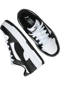 Scarpe atletiche in bianco e nero con profilo basso, realizzate in materiali sintetici. Le caratteristiche includono perforazioni e una suola testurizzata.