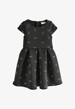 Czarna sukienka z krótkimi rękawami, plisowanym dołem oraz jasnymi wstążkami i wzorami z literą 'B'. Wykonana z gładkiego, strukturalnego materiału.