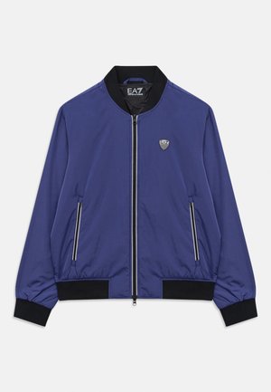 Veste bomber zippée bleue avec col, poignets et ceinture noirs, poches zippées à l'avant, et logo EA7 sur la poitrine et à l'intérieur du col.