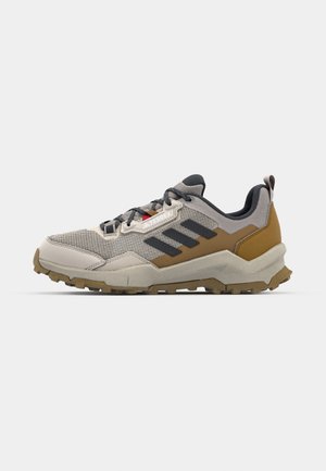 Lightweight hiking shoe in beige and brown, featuring a mesh upper, rubber sole with deep treads, and three black stripes on the side.