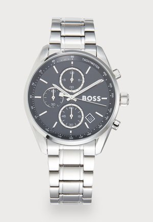 Montre-bracelet chronographe avec un bracelet en acier inoxydable, un cadran noir, des accents argentés, une échelle tachymétrique et trois sous-cadrans pour les fonctions de chronométrage.