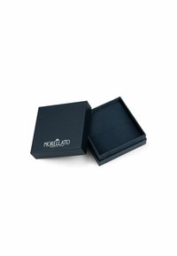 Scatola regalo nera con esterno testurizzato, con logo in rilievo e coperchio aperto che rivela un interno foderato. Nessuna decorazione o motivo aggiuntivo.