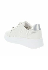 Zapatilla blanca perforada con punta redondeada, suela gruesa blanca y acento metálico plateado en el talón. Presenta ojales metálicos para los cordones.