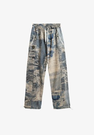 Pantalones con estampado azul y beige, fabricados en tejido texturizado, con una cinturilla elástica, cremalleras en los bolsillos laterales y puños ajustables.
