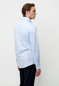Lichtblauw overhemd met lange mouwen, een puntige kraag, geruite manchetten en een rechte snit. Glad stof zonder zichtbare patronen of accenten.