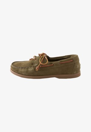 Mocassin en daim marron avec un bout cousu, des lacets en cuir noués en nœud et une semelle en caoutchouc vue de côté.