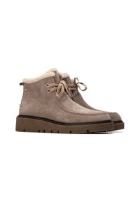 Botines de ante color beige con forro de peluche sintético, punta redonda y suela plana de goma. Incluyen cordones y ojales de metal dorado.