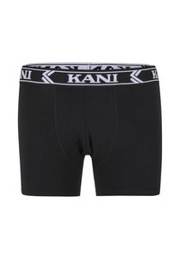 Melno vīriešu bokseršortos ar platu melnu jostu, kurā ir balti "KANI" teksti un bultu dizaini.
