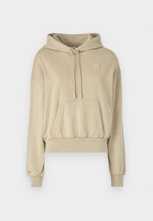 Kreminės spalvos trumpa hoodie su raišteliu reguliuojamu gobtuvu, priekinėmis kišenėmis ir švelnia tekstūra. Ant krūtinės yra mažas kvadratinis logotipas ir raukšlėtos rankogaliai.
