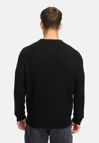 Suéter negro de punto acanalado, con escote redondo, mangas largas, tejido texturizado, puños y dobladillo ajustados, diseño casual, sin patrones ni acentos visibles.