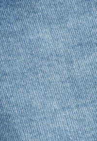 Tela de mezclilla de un azul claro con una textura sutil y un patrón de tejido diagonal visible. Superficie lisa con un color uniforme en todo.