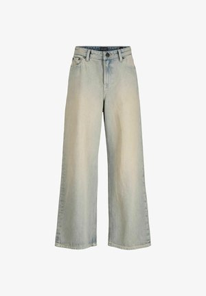 Λευκό βαμβακερό t-shirt, σε χαλαρή εφαρμογή, συνδυασμένο με τζιν ανοικτού μπλε σε gradient. Μπεζ παπούτσια και ένα ανοιχτό καπέλο με καφέ απόχρωση ολοκληρώνουν το ντύσιμο.