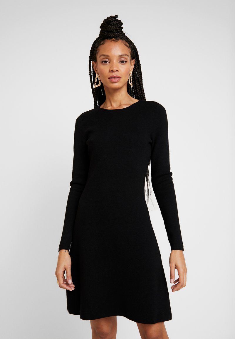 Abito lungo nero a maniche lunghe realizzato in materiale morbido, con scollatura rotonda e silhouette a trapezio. Tessuto liscio senza motivi visibili o accessori.