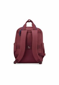Zaino bordeaux con spallacci imbottiti, maniglia superiore e tasche laterali. Texture liscia con un dettaglio del logo al centro in basso.