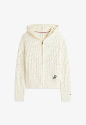 Cremefarbener Strickkapuzenpullover mit Reißverschluss, gerippten Bündchen und Saum, einer Kapuze und schwarzen bestickten Initialen auf der unteren Vorderseite.