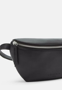 Czarna skórzana torba na ramię o gładkiej fakturze, zamykana na zamek błyskawiczny, z bocznym uchwytem; wytłoczone logo marki po jednej stronie.