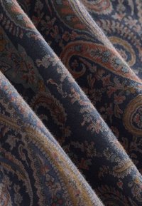 Tekstiil tumesinise taustaga, kaunistatud keerukate pärlikujuliste mustritega roosa, rohelise ja kreemika toonides. Pehme tekstuuriga ja kergelt voltuv kangas.