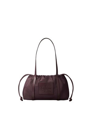Sac à main Calvin Klein en cuir marron foncé avec côtés à cordon, longues bandoulières et patch logo embossé sur le devant.