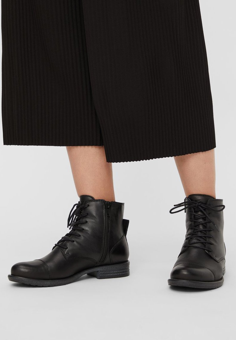 Bottines en cuir noir, avec fermeture à lacets et à glissière, bout rond, tige texturée, petit talon et détails de couture subtils.