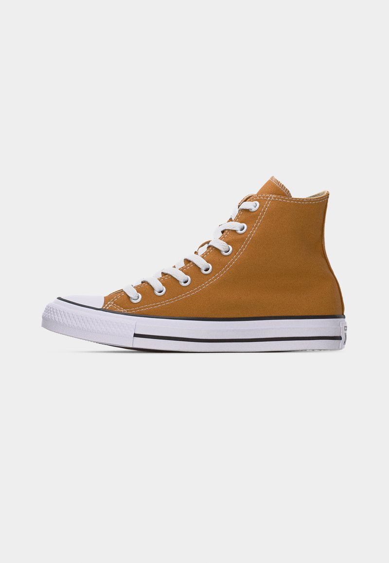 Zapatilla alta de lona marrón con cordones blancos, puntera de goma blanca y suela blanca con rayas negras, vista de perfil.