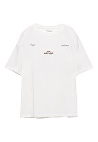 Valkoinen puuvillapaita, jossa on lyhyet hihat, pyöreä pääntie ja ruskealla tekstillä "NEW ARCHIVE" sekä lisäsuunnittelua edessä.