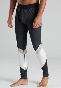 Schwarze sportliche Leggings mit einer eng anliegenden Passform, ausgestattet mit farblich abgesetzten Akzenten in Weiß und Beige, aus leichtem, glattem Stoff gefertigt.