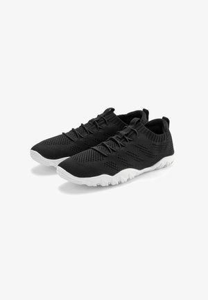 Black knitted athletic shoes with a breathable upper, white rubber sole, and textured design. Features elastic laces and pull tabs.