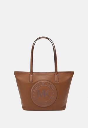 Sac fourre-tout en cuir marron avec une surface texturée, logo embossé circulaire présentant "Michael Kors" et "NY" au centre, et deux anses plates.