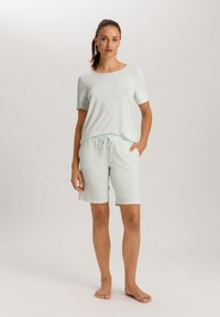 Licht mintgroen lounge set met een shirt met korte mouwen en drawstring shorts. Het shirt heeft een losse pasvorm en de shorts hebben zijzakken.