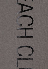 Gray fabric with vertical, large black text that reads "BEACH CLASSIC." The texture appears smooth and slightly stretchy.