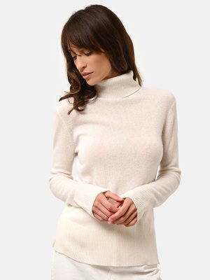 Suéter de cuello alto crema hecho de un tejido suave, con ribetes en el dobladillo y los puños, que ofrece un ajuste relajado y una textura suave.