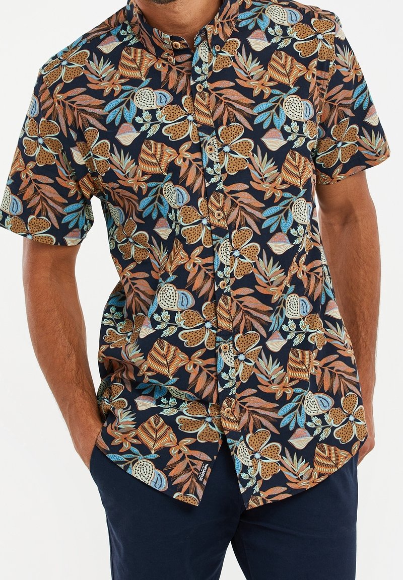 Korte mouwen overhemd in donker marineblauw met een kleurrijk bloemen- en bladenpatroon. De stof is lichtgewicht met een knoopsluiting aan de voorkant en een relaxte pasvorm.