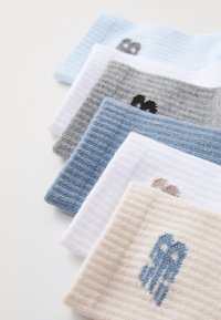 Juego de seis muestras de tela en distintas tonalidades de azul, gris y crema, con textura acanalada y pequeños diseños bordados.