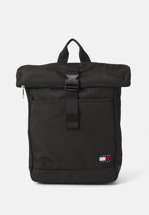 Schwarzer rechteckiger Rucksack mit Rolltop-Klappe, die durch eine Schnalle gesichert ist, einer vorderen Reißverschlusstasche, Tragegriff und kleinem Tommy Jeans Logo-Patch.