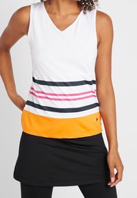 Top bianco senza maniche con scollo a V, caratterizzato da righe orizzontali in rosa, blu navy e bianco, con un bordo inferiore arancione; abbinato a una gonna nera.