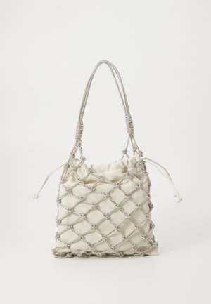 Tas gemaakt van crème stof met een zilveren netontwerp, sluiting met trekkoord en textuur handvatten. Bevat decoratieve knopen door het net.