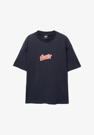 T-shirt en coton bleu marine à manches courtes ; présente un logo rouge et blanc sur la poitrine. Encolure ronde, coupe décontractée, texture lisse.