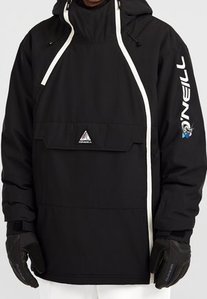 Man draagt een zwarte O'Neill capuchonjas met witte ritssluitingdetails en logo op de mouw, gecombineerd met zwarte handschoenen en witte broek.
