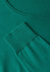 Grüner gestrickter Pullover mit einer glatten Textur, weitem Rundhalsausschnitt und gerippten Ärmelabschlüssen. Das Material wirkt weich und bequem.