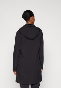 Manteau noir à capuche avec une coupe décontractée et une texture solide. Il présente une couture frontale et des manches longues, conçu pour la chaleur et le confort.