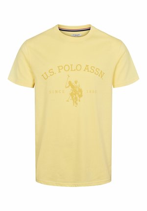 Žuta pamučna majica s okruglim izrezom, koja sadrži veliki, tonirani logo U.S. Polo Assn. i grafiku igrača polo na konju.