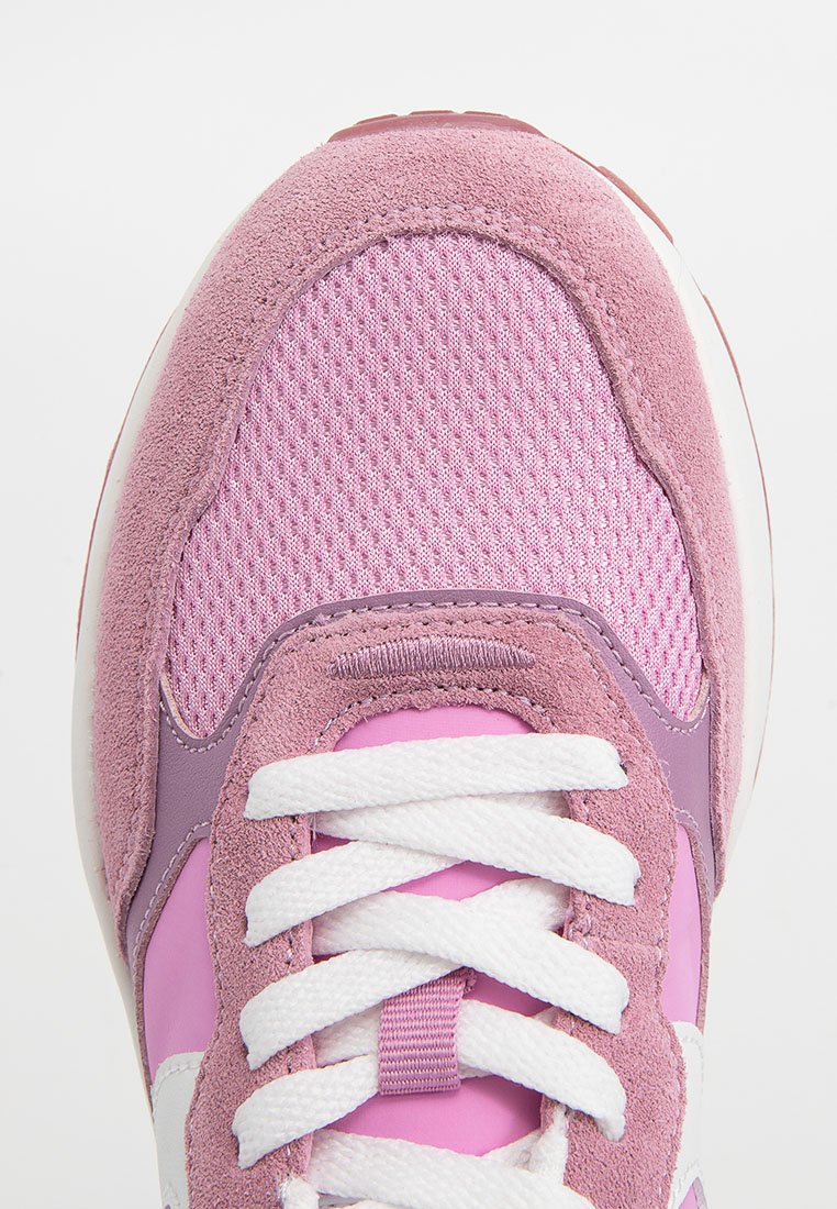 Close-up van de voorkant van een roze en paarse sneaker met suède en mesh texturen, en witte veters die in een strik zijn geknoopt.
