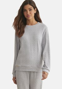 Lichtgrijze sweatshirt met lange mouwen, voorzien van een gestructureerd ruitpatroon, ronde halslijn en rib gebreide manchetten. Zachte stof, relaxte fit.