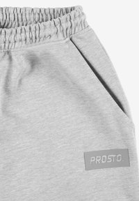 Szare dresy z elastycznym paskiem w talii, wykonane z miękkiego materiału, z prostokątną szaro-rubberową naszywką z napisem "PROSTO".