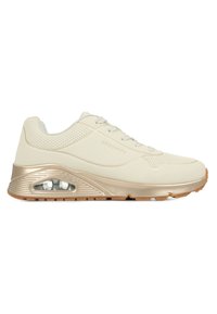 Beżowe buty sportowe z gładką skórzaną cholewką, perforowanymi sekcjami, sznurowanym zapięciem i złotymi akcentami na podeszwie z poduszką powietrzną.