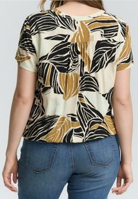 Kortærmet bluse med bladmønster i sort, guld og cream. Løs pasform med plissering på ryggen, lavet af glat stof.