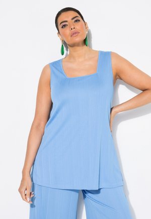 Top senza maniche di un blu chiaro con scollatura quadrata, texture a coste e vestibilità ampia, abbinato a pantaloni dello stesso blu chiaro.