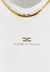 White T-shirt featuring a gold logo "ELISABETTA FRANCHI" and a gold chain necklace with curved accents, highlighting a smooth texture.
