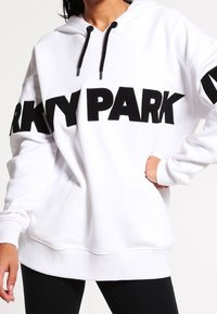 Felpa bianca con cappuccio e grande scritta nera "PARK". Caratterizzata da cordini, maniche lunghe e orlo a coste. Realizzata in tessuto morbido.