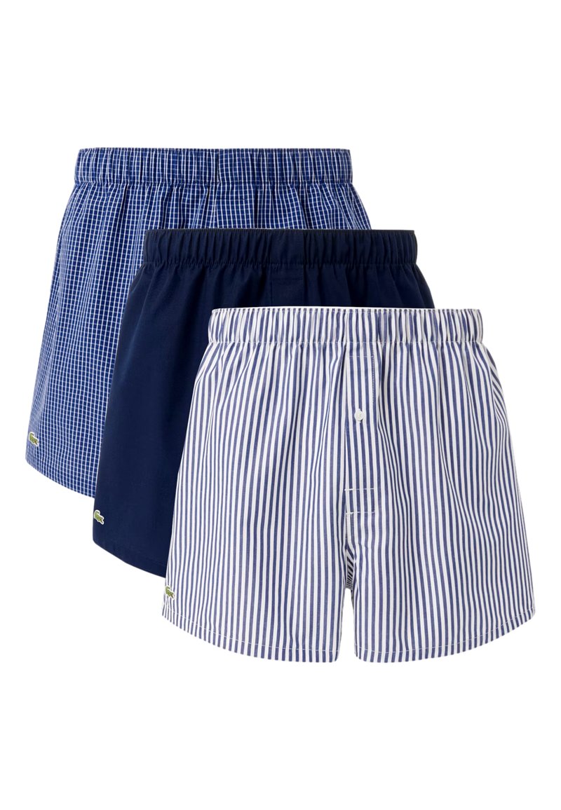 Three pairs of boxers in cotton. Features include a blue check pattern, solid navy, and blue stripes with elastic waistbands and small logos.